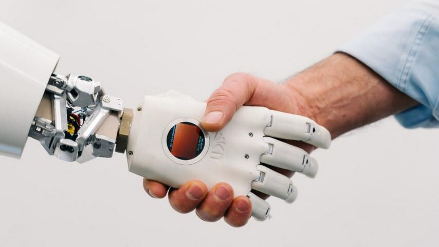 Der humanoide Roboter ARMAR-7 gibt einem menschen die Hand